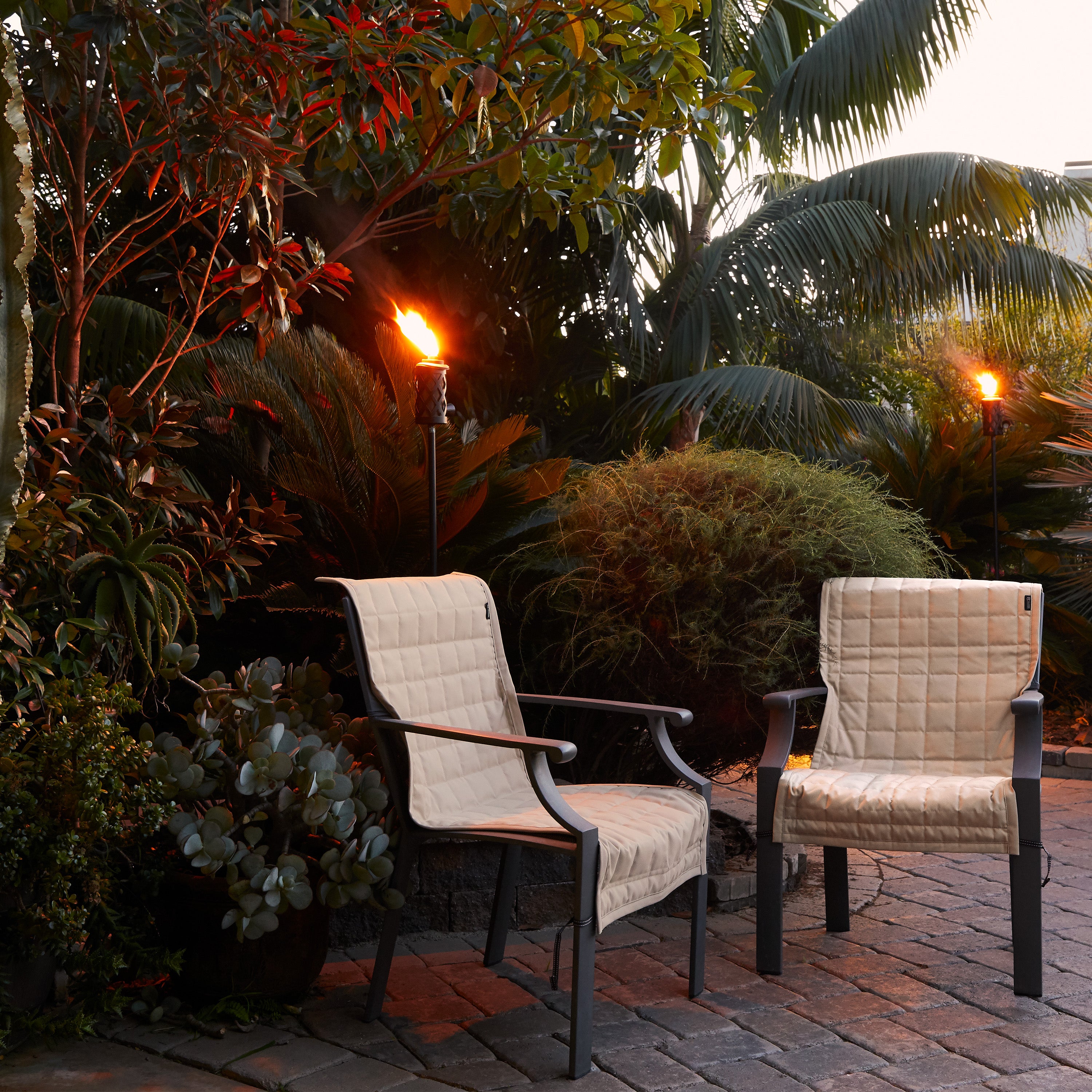 56-010_Patio_Montlake_FadeSafe_Slip_Cover_Chair_LifestyleTorches_AntiqueBeige_Detail.jpg